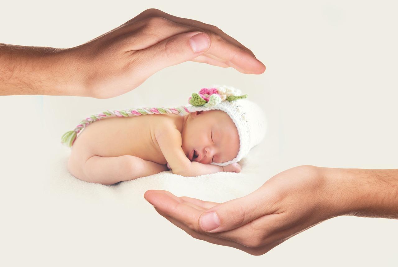 Сделано с заботой. Ладонь ребенка. Новорожденный на руках. Младенец на руках. Забота о новорожденных.