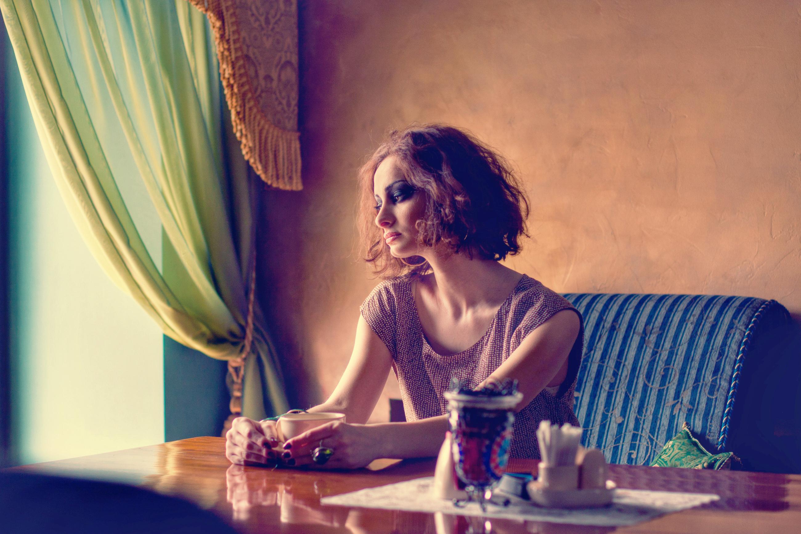 Тоскующая женщина. Одинокая женщина. Красивая одинокая женщина. Девушка сидит в кафе. Одиночество девушка.